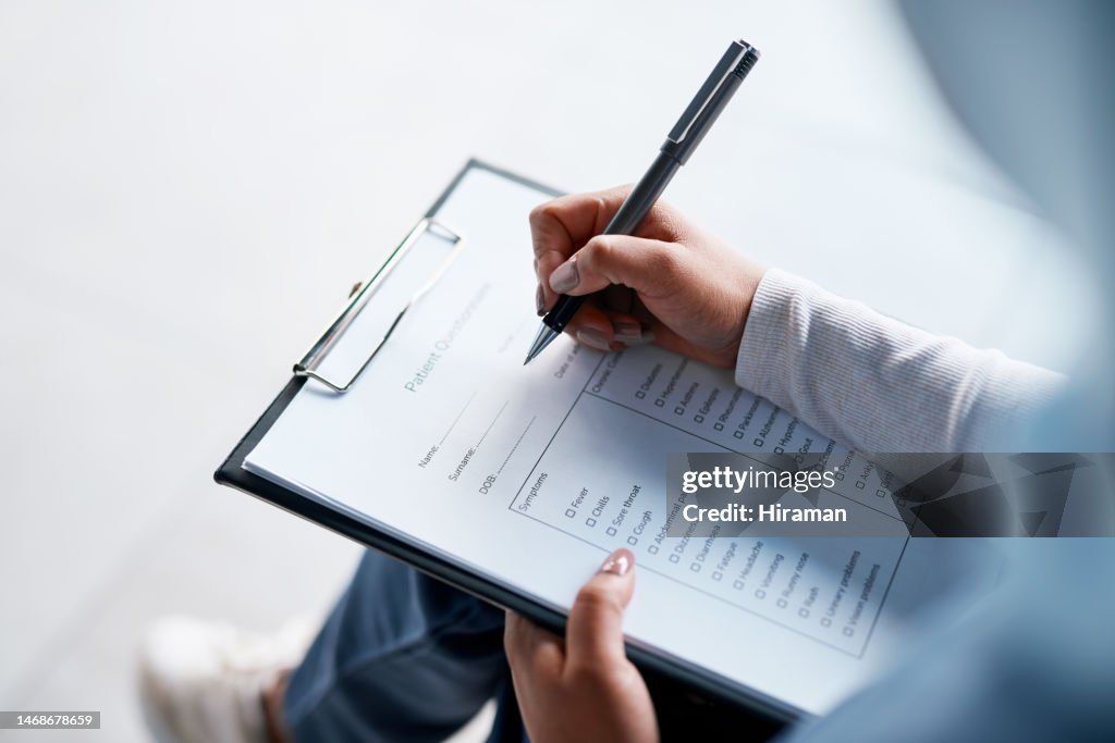 Hands, documents and writing with a woman in a hospital, filling out an application or questionnaire for healthcare overhead. Medical, checklist and paperwork with a person filing an insurance report