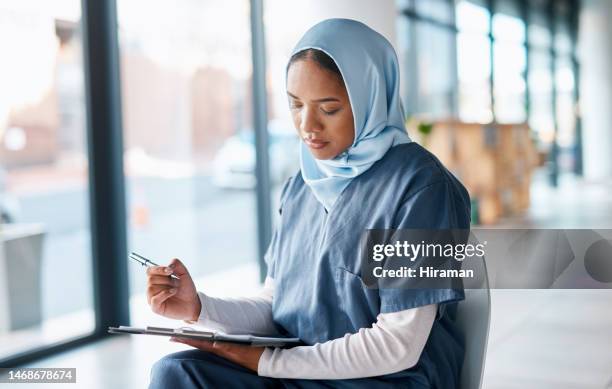 healthcare, doctor and muslim woman writing on paperwork for insurance, diagnosis and prescription. hospital, clinic and islamic nurse with application form for medical report, review and results - arabic doctor stockfoto's en -beelden