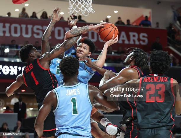 Tylan Pope of the Tulane Green Wave is fouled by Jamal Shead of the Houston Cougars as he drives to the basket during the first half at Fertitta...
