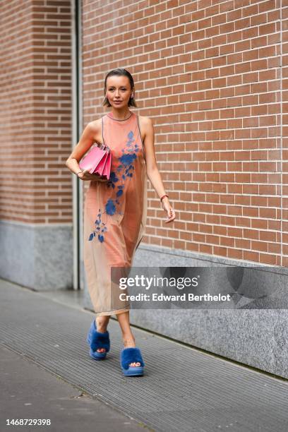 Nataly Osmann wears a beige tulle with embroidered navy blue flower pattern tank-top long dress from Fendi , a neon pink shiny varnished leather...
