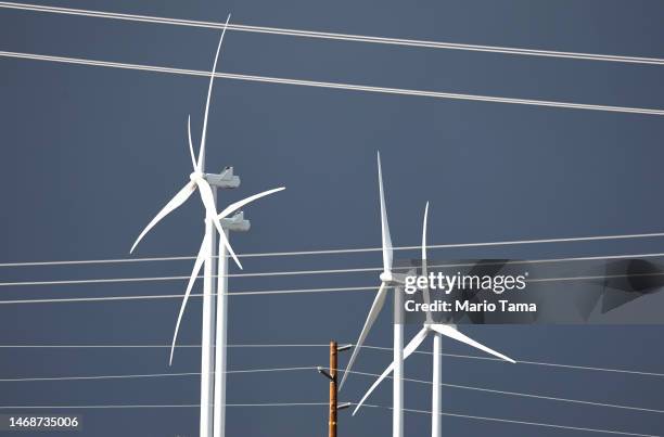 Wind turbines operate near power lines at a wind farm, a key power source for the Coachella Valley, on February 22, 2023 near Whitewater, California....