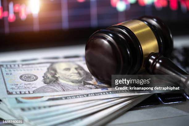 investment concept,us paper currency on laptop and gavel,money with a hammer - lawsuit stock-fotos und bilder