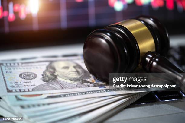 investment concept,us paper currency on laptop and gavel,money with a hammer - lawsuit fotografías e imágenes de stock