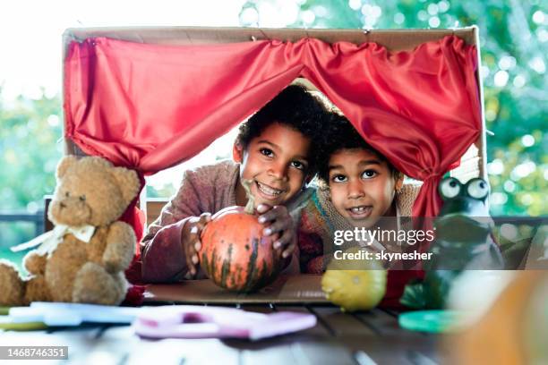 happy black kids having a puppet show on a terrace. - puppet show stock pictures, royalty-free photos & images