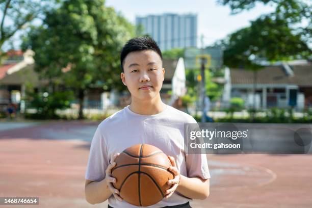 man holding soccer ball looking at camera. - only teenage boys stock pictures, royalty-free photos & images