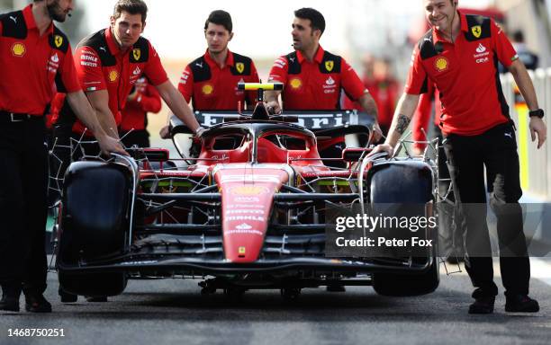 The car of Carlos Sainz of Spain and Ferrari is pushed in the Pitlane during day one of F1 Testing at Bahrain International Circuit on February 23,...