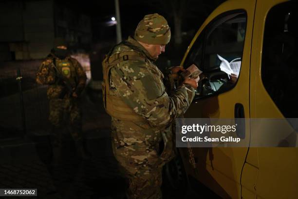 Yaroslav Kryvulya, a reserve officer in the Ukrainian army who leads a local paramilitary civil formation called TSEL, checks the identity documents...