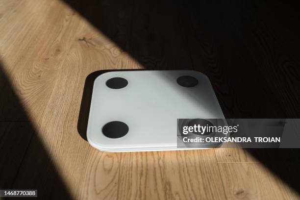 weight scales on wooden floor in sun light and shadows - beam scales stock-fotos und bilder