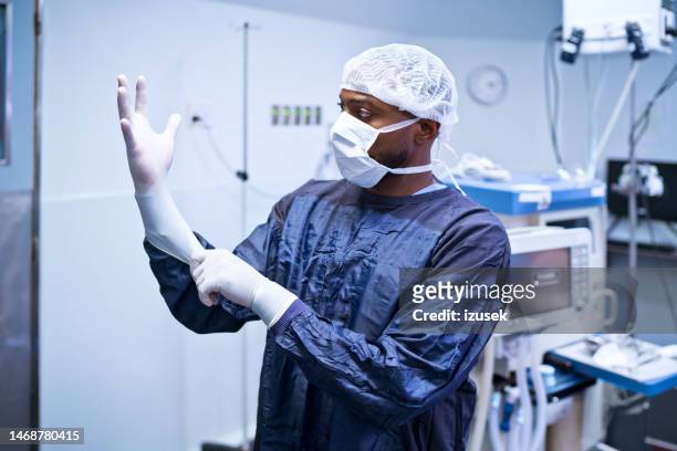 chirurg steht in der notaufnahme - operationskittel stock-fotos und bilder