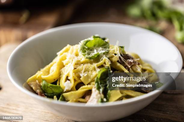 pappardelle pasta with olive oil, parmesan and basil in a white bowl. italian and mediterranean cuisine. - フェットチーネ ストックフォトと画像