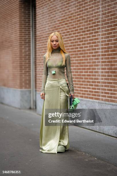 Guest wears a khaki ribbed wool turtleneck / long sleeves t-shirt, a khaki bra underwear, a pale green shiny leather bag necklace from Fendi, a pale...