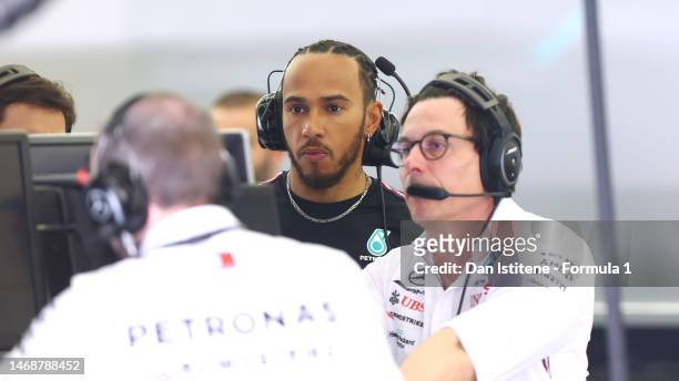 Lewis Hamilton of Great Britain and Mercedes and Mercedes GP Executive Director Toto Wolff look on in the garage during day one of F1 Testing at...