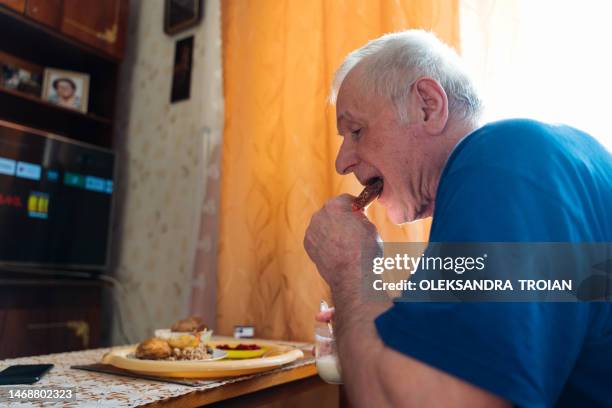 old man eating at home in living room - pension ukraine stock pictures, royalty-free photos & images