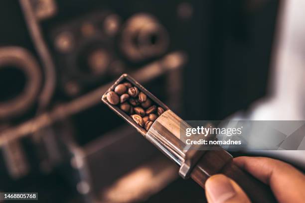 sample spoon for check roasted coffee beans, coffee beans roasted by coffee roasting machine. - coffee roasting stock pictures, royalty-free photos & images