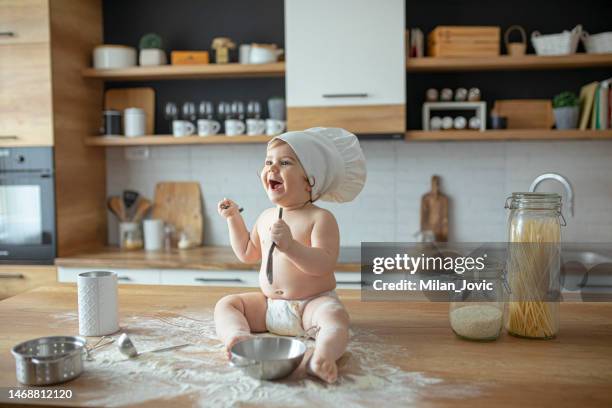 boy playing with flour and sitting on kitchen counter - baby chef stock pictures, royalty-free photos & images