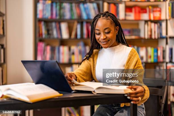 attractive young female university student using a laptop while studying - lovely professional university stock pictures, royalty-free photos & images