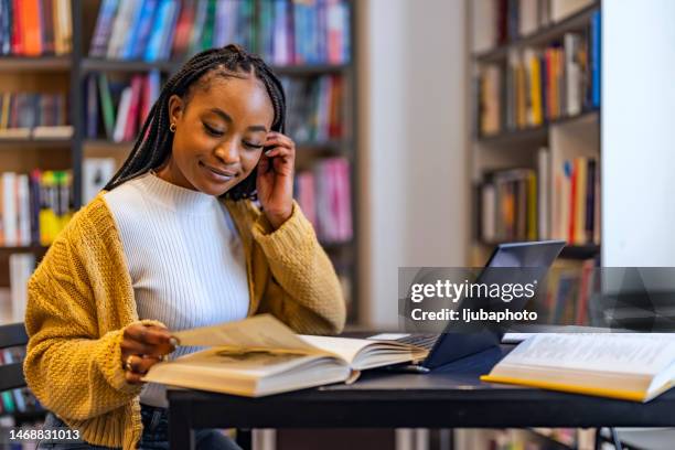 young beautiful african american woman studying at home - american literature stock pictures, royalty-free photos & images