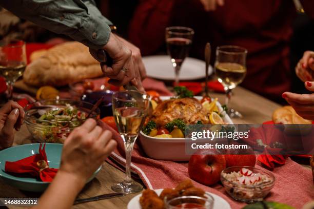 man slicing into a roasted chicken to serve for his friends during a dinner party - serving dish stock pictures, royalty-free photos & images