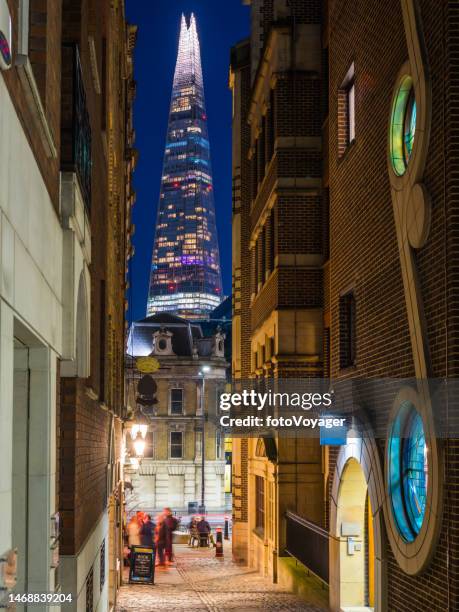 london the shard illuminated at night overlooking city alleyways pubs - urban road night stock pictures, royalty-free photos & images