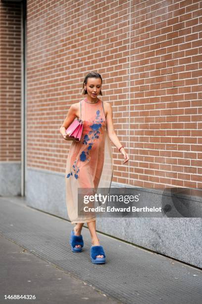 Nataly Osmann wears a beige tulle with embroidered navy blue flower pattern tank-top long dress from Fendi , a neon pink shiny varnished leather...