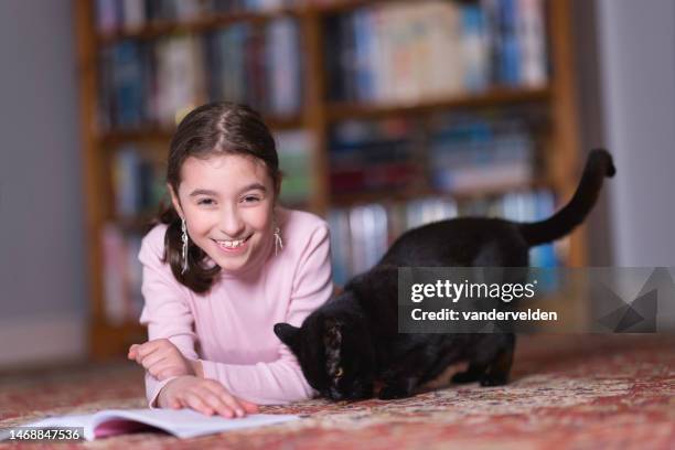 little girl reading on the floor - cat laughing stock pictures, royalty-free photos & images