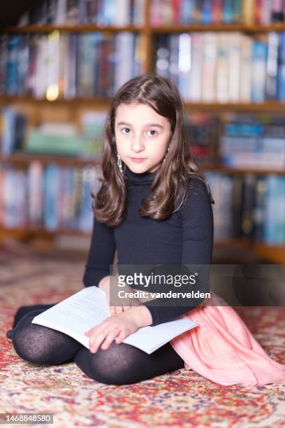 little girl reading in on the floor - curled up reading stock pictures, royalty-free photos & images