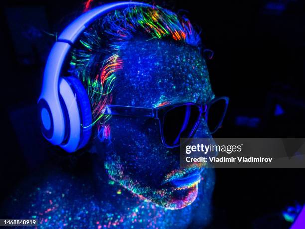 a dj with headphones under uv lights - robot mouth stock pictures, royalty-free photos & images