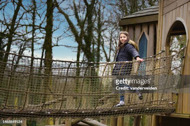 happy little girl climbing - hanging bridge stock pictures, royalty-free photos & images