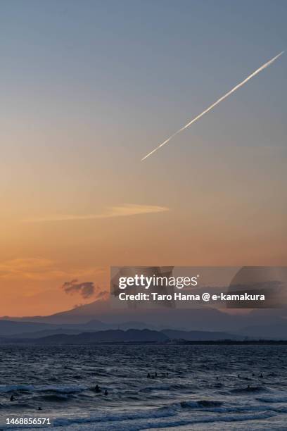 the airplane flying over mt. fuji and sunset beach in kanagawa of japan - sunset contrail stock pictures, royalty-free photos & images