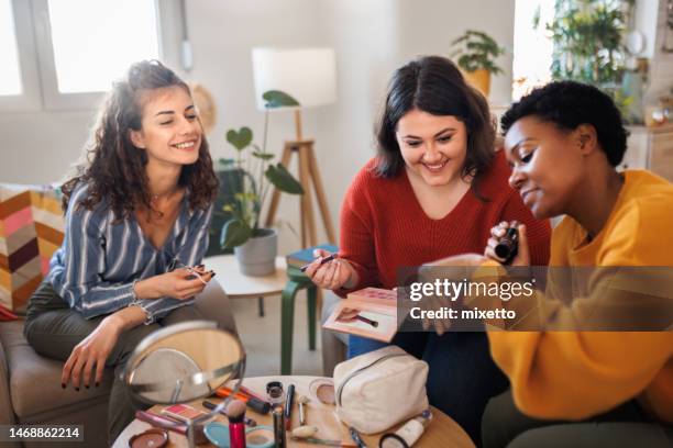 happy girls applying make up at home - plump girls stockfoto's en -beelden