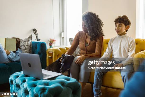 telemedicine for pets: multiracial mother and son utilize video conferencing for urgent vet consultation - mother daughter webcam stockfoto's en -beelden