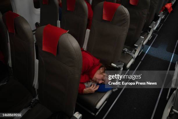 An aid worker sleeps on an airplane seat upon her arrival at the field hospital of the Spanish Agency for International Development Cooperation on...