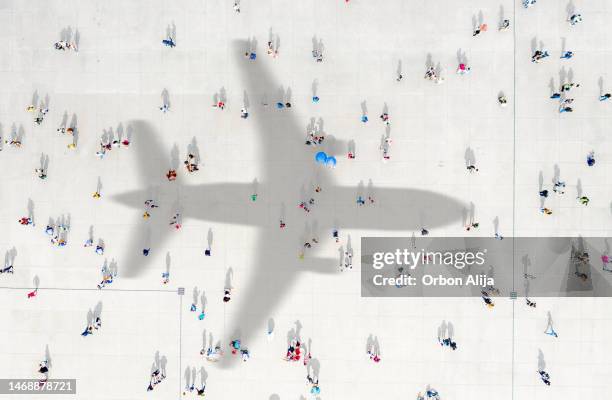 aerial view of crowd with airplane shadow - crowded airplane stock pictures, royalty-free photos & images