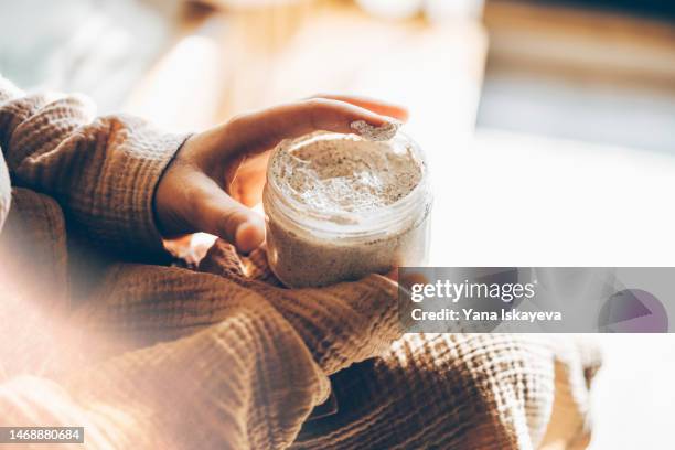 tender woman hands using shea butter body scrub - hautpeeling stock-fotos und bilder