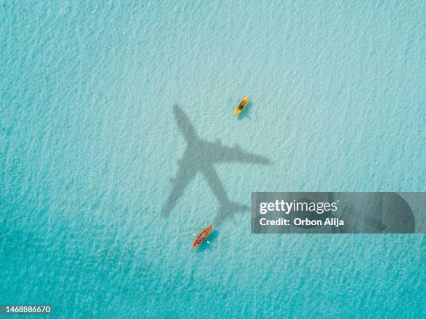 airplane flying over the sea - plane shadow stock pictures, royalty-free photos & images