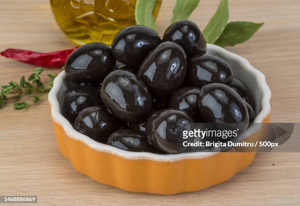 high angle view of olives in bowl on table,vaslui,romania - black olive stockfoto's en -beelden