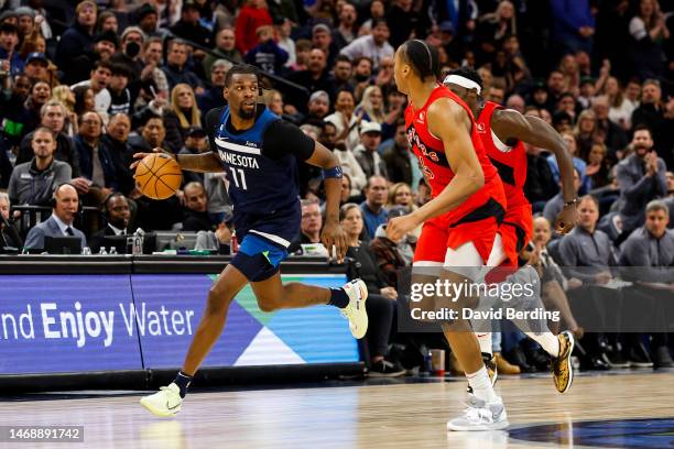 Naz Reid of the Minnesota Timberwolves dribbles the ball while Scottie Barnes of the Toronto Raptors defends in the fourth quarter of the game at...