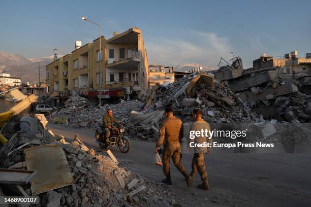 Several people walk through the rubble of buildings toppled by the earthquake, Feb. 23 in Iskenderun, Turkey . The death toll from the earthquakes,...