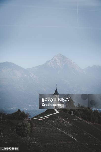 jamnik church on a hillside on a sunny autumn day against blue cloudy sky background in slovenia, europe. - church sunset rural scene stock pictures, royalty-free photos & images