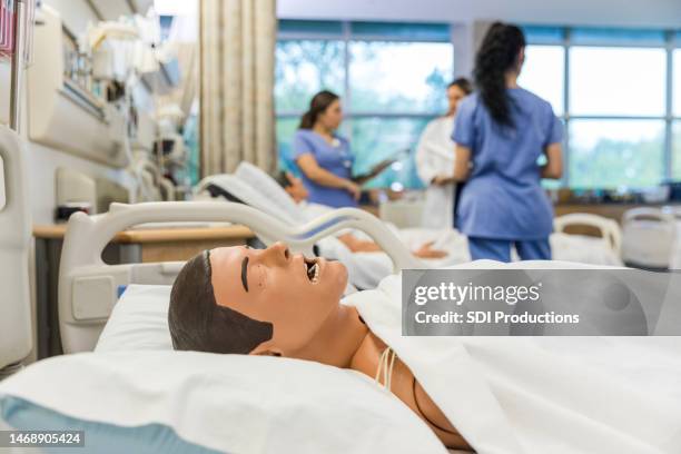 close up photo of cpr dummy lying in a hospital bed of the medical training classroom - mannequin stock pictures, royalty-free photos & images