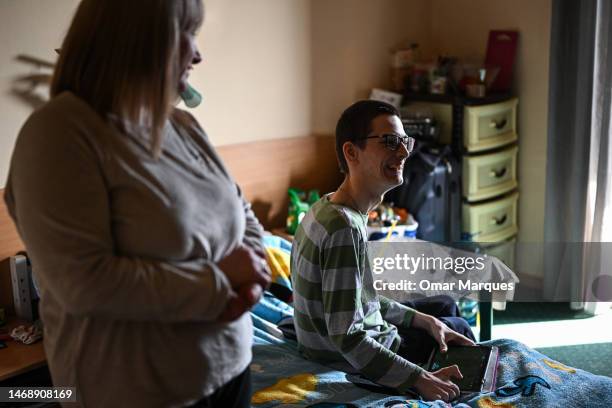 Ina, age 47 who is from Dnipro Oblast looks to her son, Jaroslaw, age 19 who suffers from with a chronic illness in their room at the Green Hotel on...