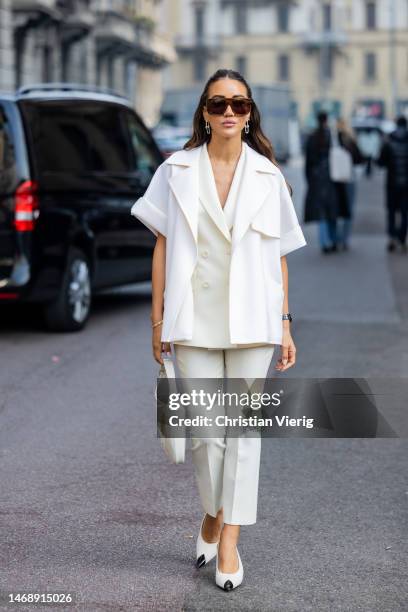 Tamara Kalinic wears creme white blazer, short sleeved jacket, pants, bag, pointed black white heels, sunglasses outside Max Mara during the Milan...