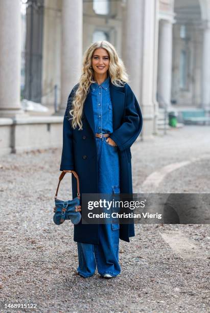 Emili Sindlev wears navy coat, denim bag, denim shirt, wide leg pants with side pockets outside Max Mara during the Milan Fashion Week Womenswear...