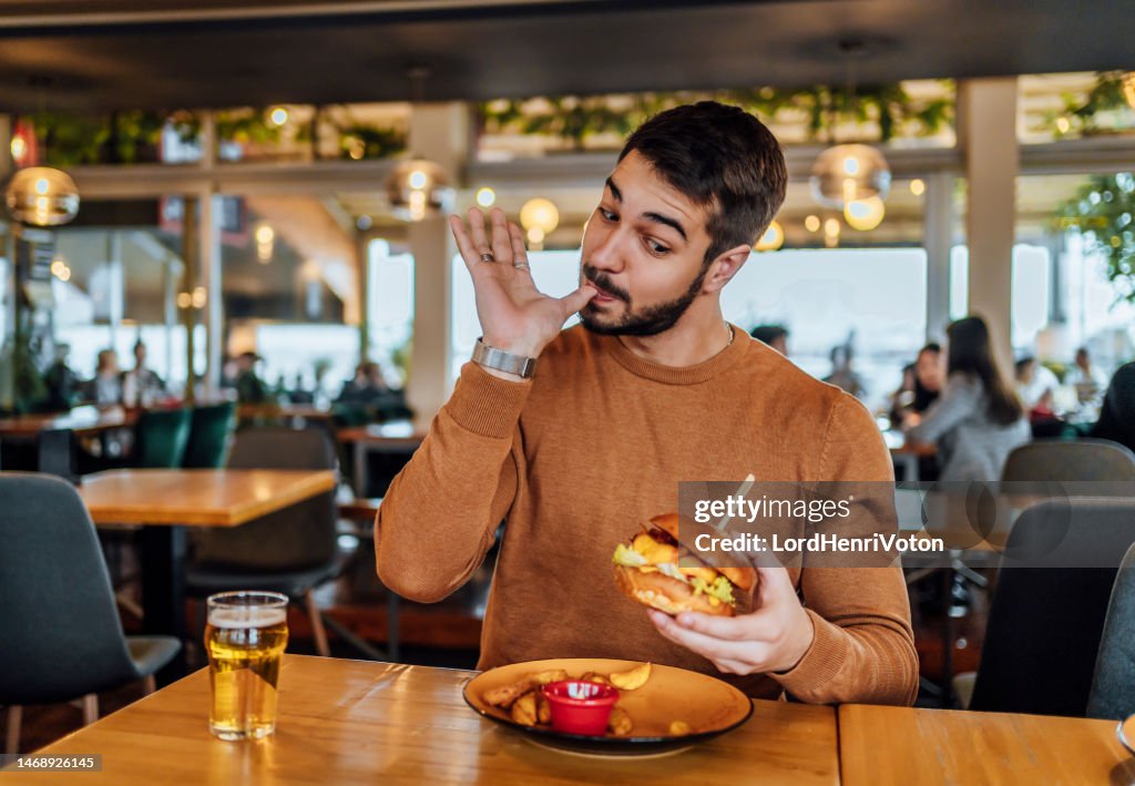 Giovane che gode di un delizioso hamburger