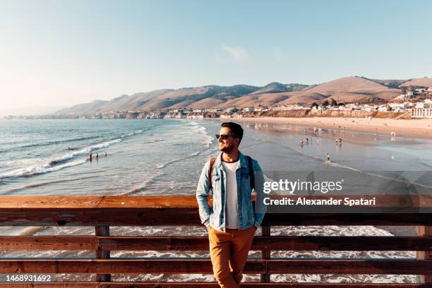 young happy smiling man in sunglasses at pismo beach, california, usa - stati uniti occidentali foto e immagini stock