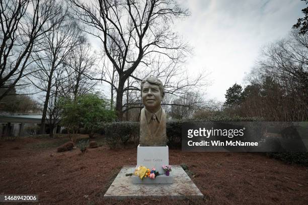 Flowers are left at the base of a giant bust of former U.S. President Jimmy Carter at the Jimmy Carter Library and Museum February 23, 2023 in...