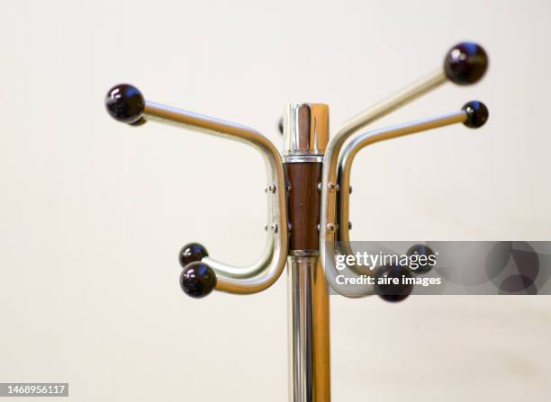 close-up of high part of silver coat rack with black spheres on the tips on white background - white coat fashion item stockfoto's en -beelden