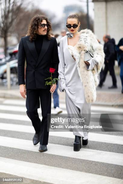 Guests are seen wearing black sunglasses, a black turtleneck shirt, a black suit and black leather boots and the other black Balenciaga sunglasses,...