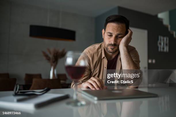 unemployed entrepreneur having problems and drinking at home. - dronken stockfoto's en -beelden