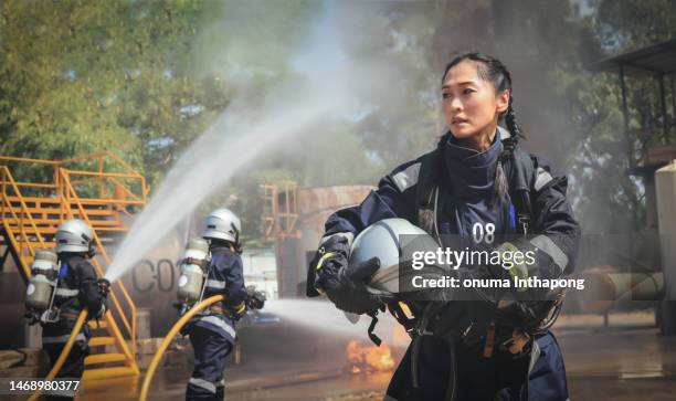 portrait female firefighters extinguishing hard working  at   accident site, international woman days , professional female firefighter hold helmet walk back to break after job done - female rescue worker stock pictures, royalty-free photos & images